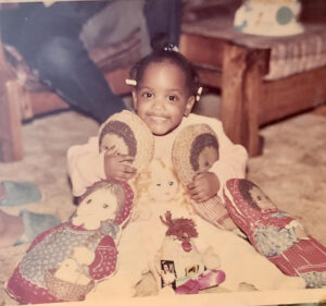 Ashley as a child surrounded by dolls--stuffed and unstuffed.