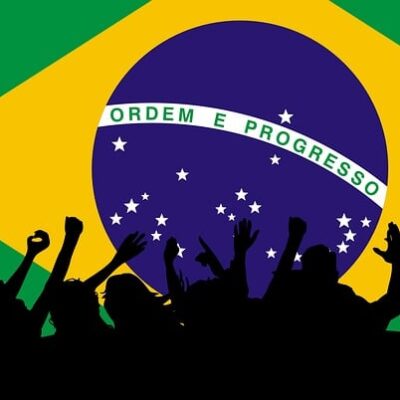 Brazilian flag with silhouettes of people in movement in front